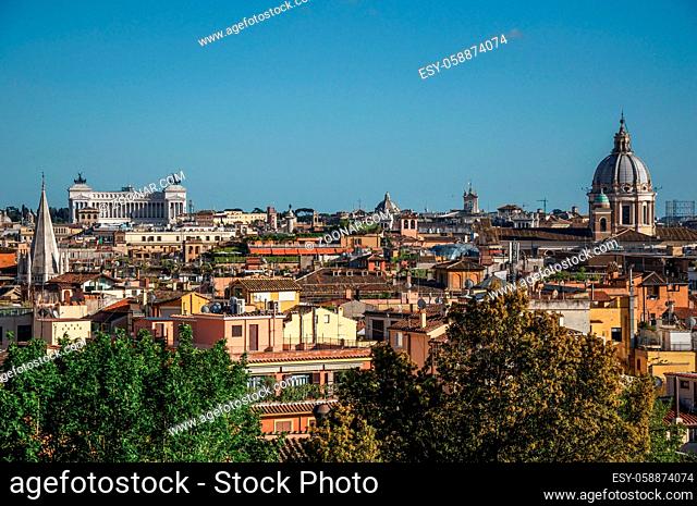 Overview of trees, cathedrals domes and roofs of buildings in the sunset of Rome, the incredible city of the Ancient Era, known as The Eternal City