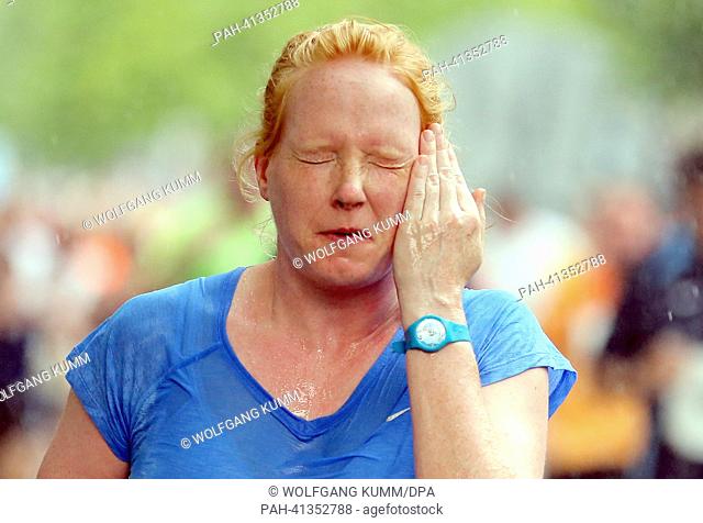 A participant of the 22nd Vattenfall City-Night wipes sweat from her face during the five kilometre long run along the Kurfuerstendamm at temperatures around 30...