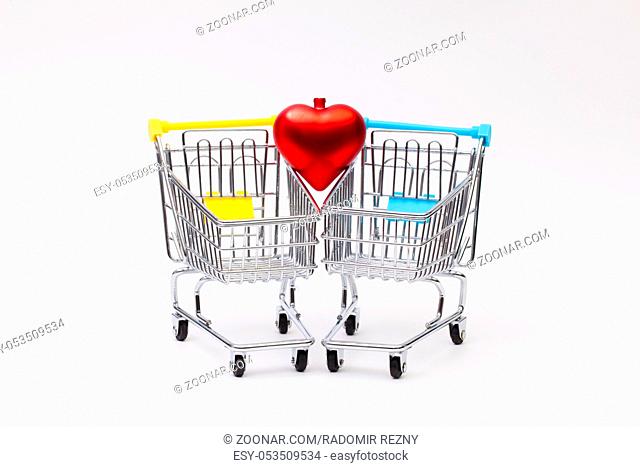 Two shopping trolley and red heard on the white background