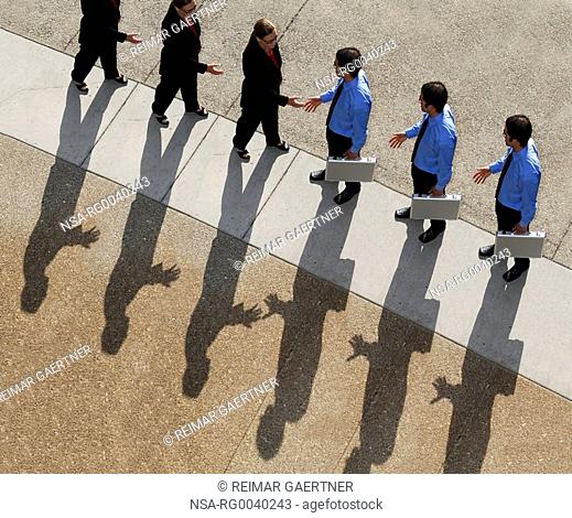 Cloned businessman and woman with shadow shaking hands