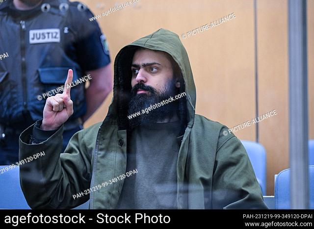 19 December 2023, North Rhine-Westphalia, Duesseldorf: The accused Maan D. waits for the start of the trial in the Duisburg knife attack trial and shows the...