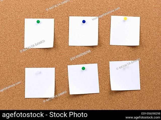 white square blank pieces of paper pinned on a cork board, copy space