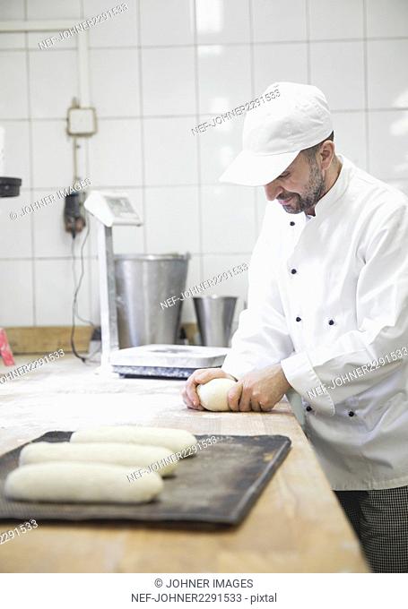 Baker preparing dough in kitchen