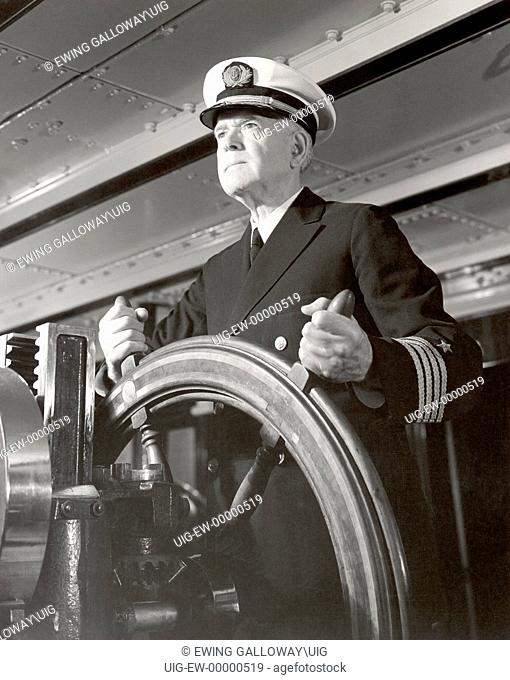 Captain operating ships steering wheel