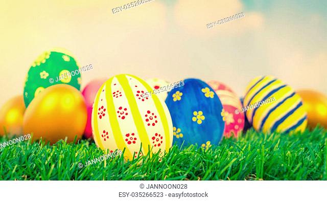 Easter Eggs on Fresh Green Grass over blue sky ( Filtered image processed vintage effect. )