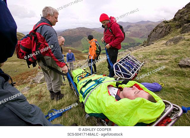 The Langdale Ambleside Mountain Rescue Team stretcher an injured hiker of the Langdale Fells in the Lake District UK