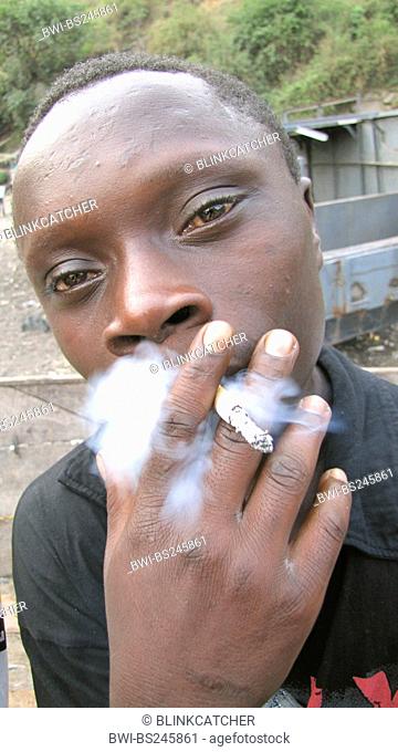 teenager drug addict with reddened eyes smoking a cigarette near the harbour of Goma, Republic of the Congo, North Kivu, Goma