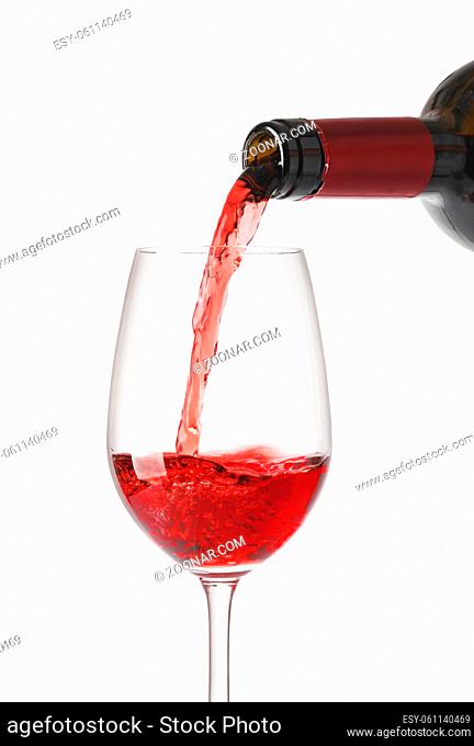red wine pouring in glass, isolated on white