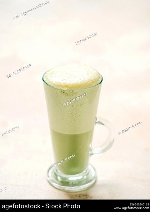 Matcha green tea latte in glass. Matcha latte on light background. Copy space. Vertical Vertical