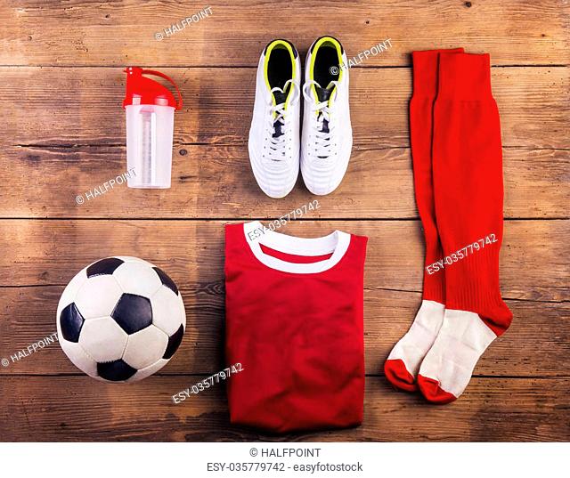 Various football stuff lined up on a wooden floor background