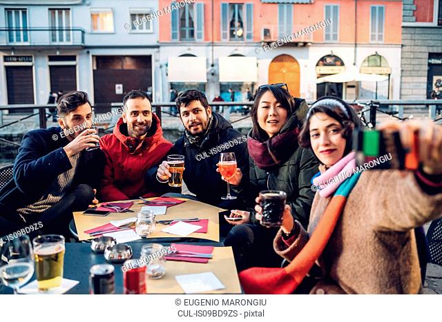 Friends enjoying drink at outdoor cafe, Milan, Italy