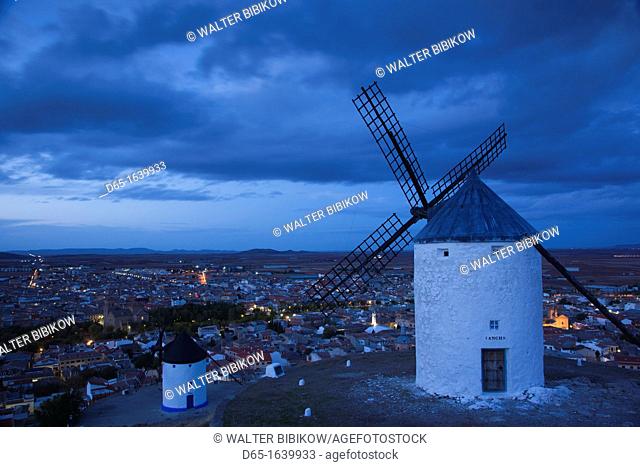 Spain, Castile-La Mancha Region, Toledo Province, La Mancha Area, Consuegra, antique La Mancha windmills and elevated town view, dusk