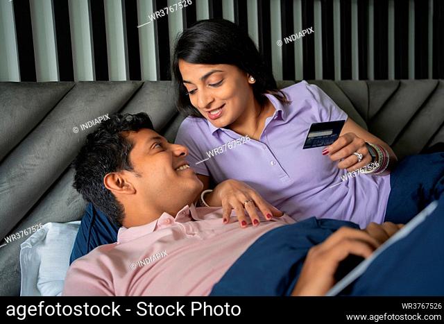 Young couple in the middle of a discussion while shopping online with credit card
