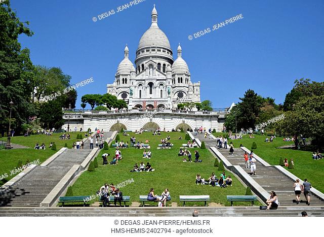 France, Paris, Sacre Coeur Basilica of Montmartre, staircases surrounded with lawns at the foot of a religious building