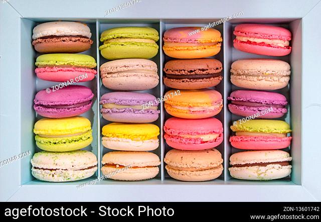 Set of different french cookies macaroons macaroons in a paper box. Top view. Coffee, chocolate, vanilla, lemon, rapsberry, strawberry, pistachio, violet, rose