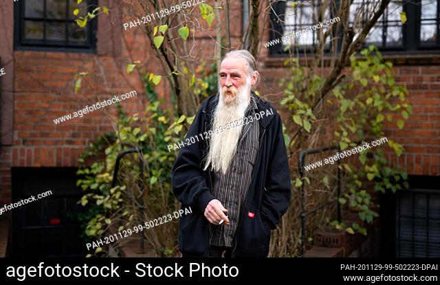 23 November 2020, Hamburg: Volker Mähl stands in the backyard of a hotel in Hamburg-Altona and smokes a cigarette. Mähl is homeless and one of twenty people for...