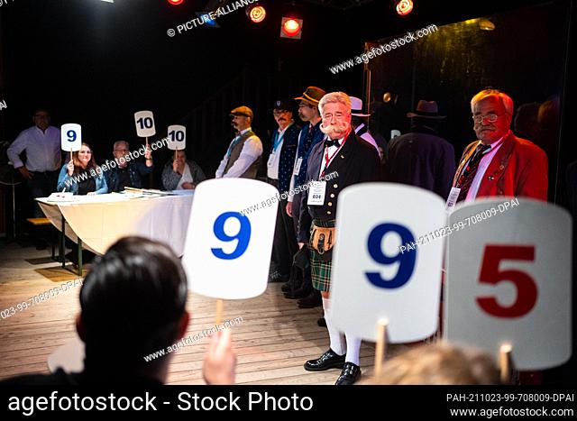 23 October 2021, Bavaria, Eging Am See: The jury of the Beard Olympics gives its rating for a participant in the category ""Schnauzbart Naturale"" in the Music...