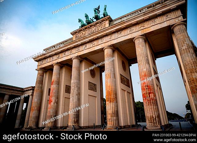 03 October 2023, Berlin: The color of an action of the last generation is still visible at the Brandenburg Gate in the early morning