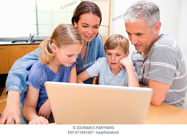 Charming family using a notebook
