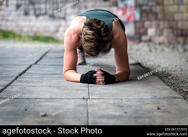 Active 36 year old white woman planking under a bridge outdoors, Brussels, Belgium