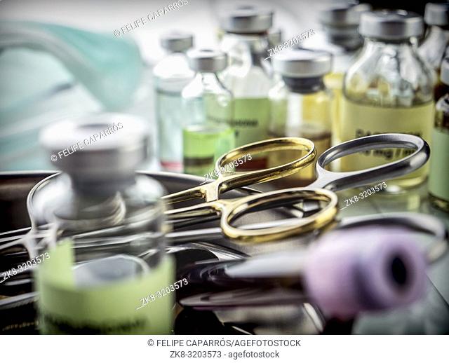 Several scissors of suture and syringes in an operating theater, conceptual image