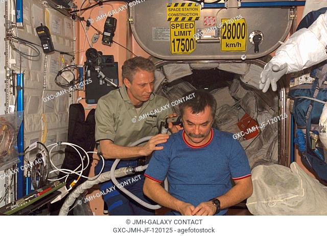 European Space Agency (ESA) astronaut Thomas Reiter, Expedition 14 flight engineer, cuts the hair of cosmonaut Mikhail Tyurin