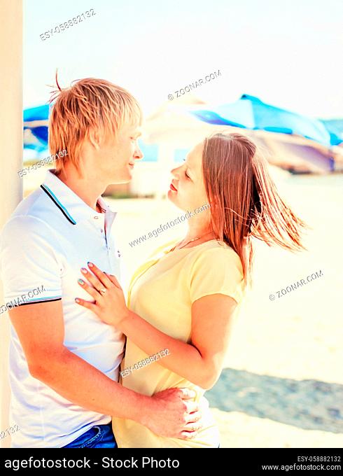 Young couple in love having fun and jumping on the beach at summer day