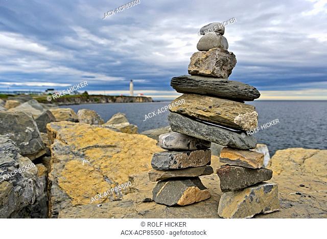 Stone figure with Cap-des-Rosiers Lighthouse in the background, Land's End, Gaspesie, Gaspesie Peninsula, Highway 132, Quebec, Canada