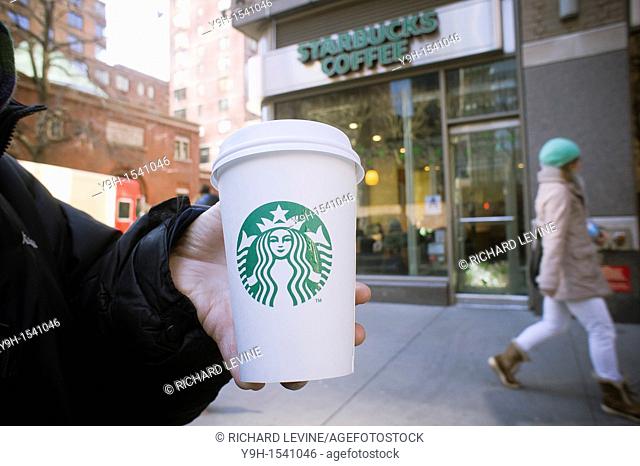 A Starbucks coffee cup with their new sans-typography logo is seen in Midtown Manhattan in New York Starbucks has rolled out its new logo