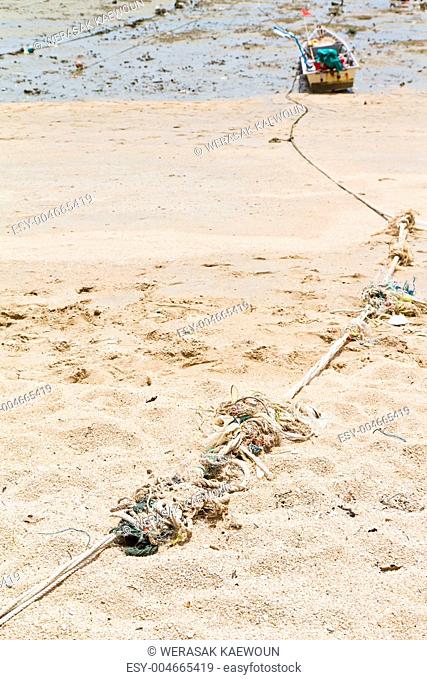 Rope tied to a fishing boat on the beach