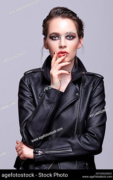 Portrait of female in black leather jacket. Woman with unusual beauty evening makeup. Girl with perfect skin, green pistachio colour eyes and violet - black...