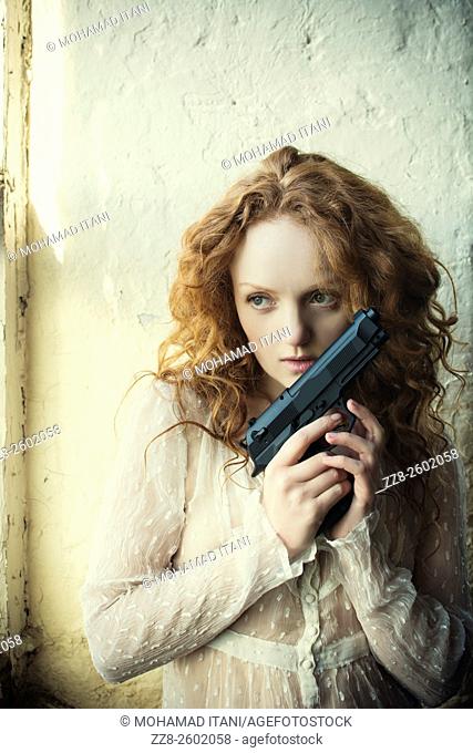 Redhead woman holding a gun