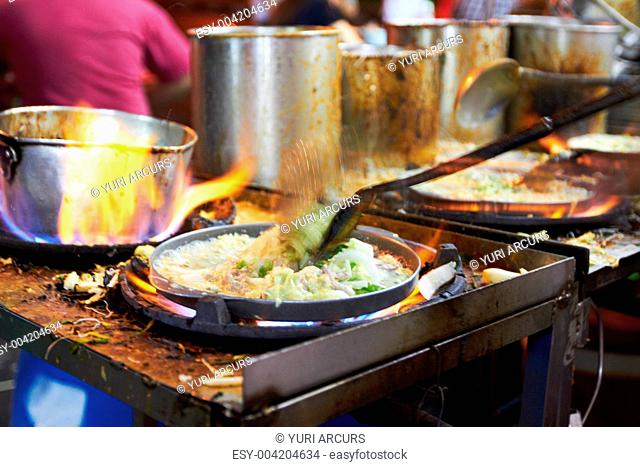 Food being prepared in a restuarant kitchen on a gas gass stovetop