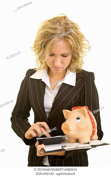 Blonde Frau im Jackett hält ein Klemmbrett mit Taschenrechner und Sparschwein