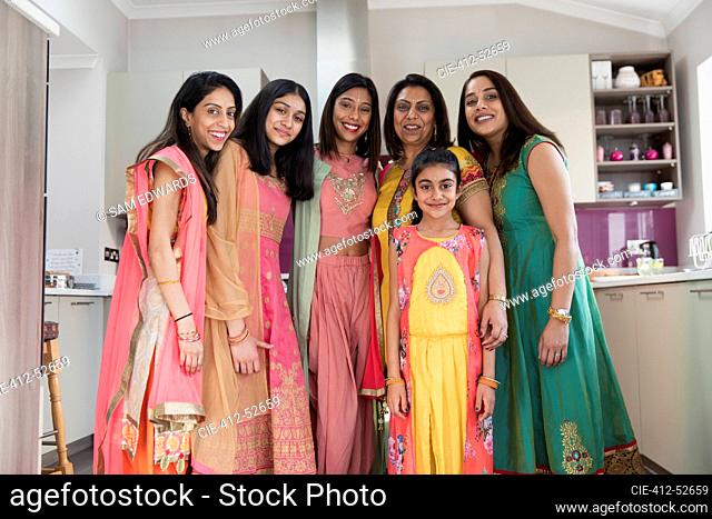 Portrait happy Indian women and girls in saris in kitchen
