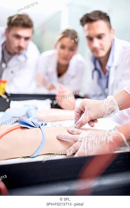 Doctor practising inserting an IV line