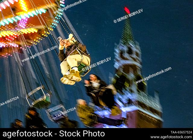 RUSSIA, MOSCOW - DECEMBER 11, 2023: Citizens enjoy a swing ride during the GUM Christmas Fair in Red Square. Sergei Bobylev/TASS