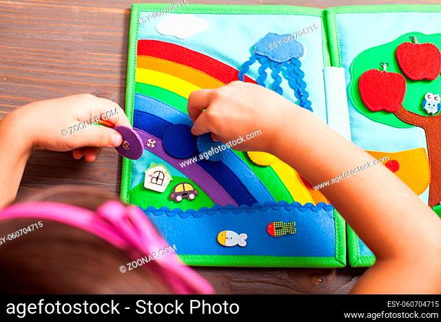Top view of the girl who is laying out circles for rainbow colors in the quiet book