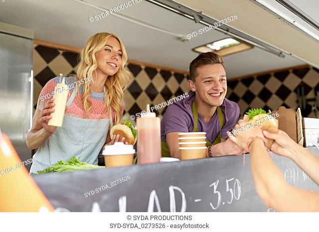 happy sellers serving customers at food truck