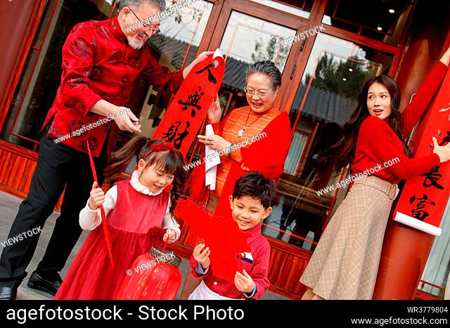 Happy family to stick couplets on the Spring Festival to celebrate the New Year