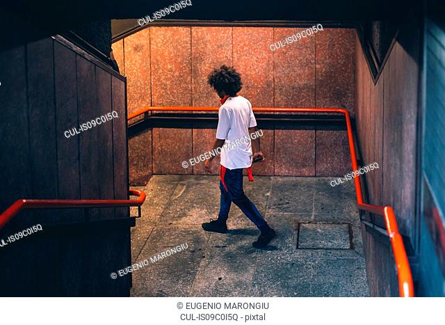 Young man descending stairway