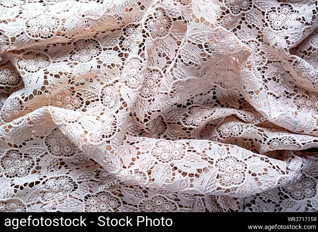 Soft folds of a white genuine traditional lace placemat to be used as background