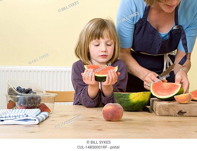 girl and mother with watermelon slices