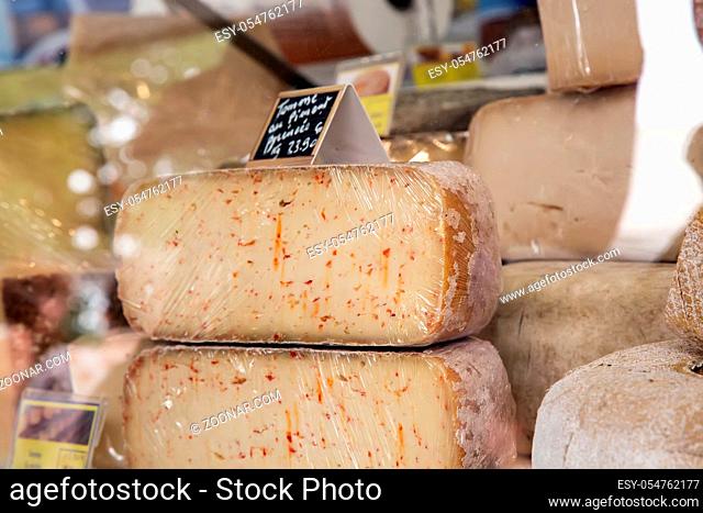 Natural mountain cheeses with mold on rind exposed in local market