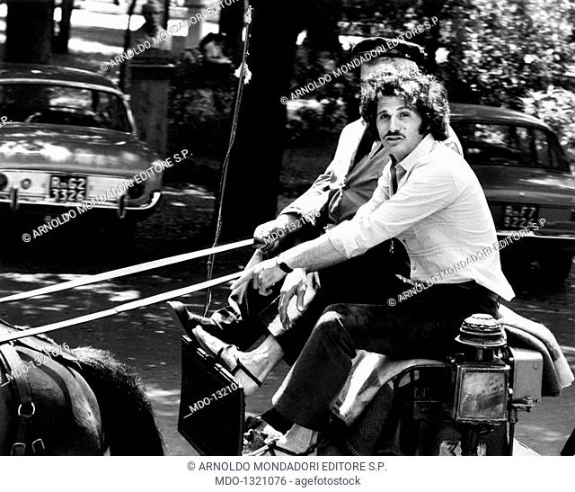 Tony Musante on a cart. The American actor Tony Musante (Anthony Peter Musante) travelling on a cart. Rome, 1970s