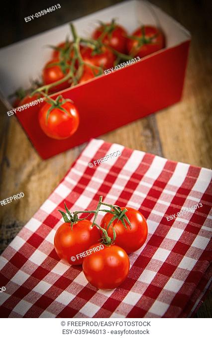 Fresh cherry tomatoes on travel and wooden background, France