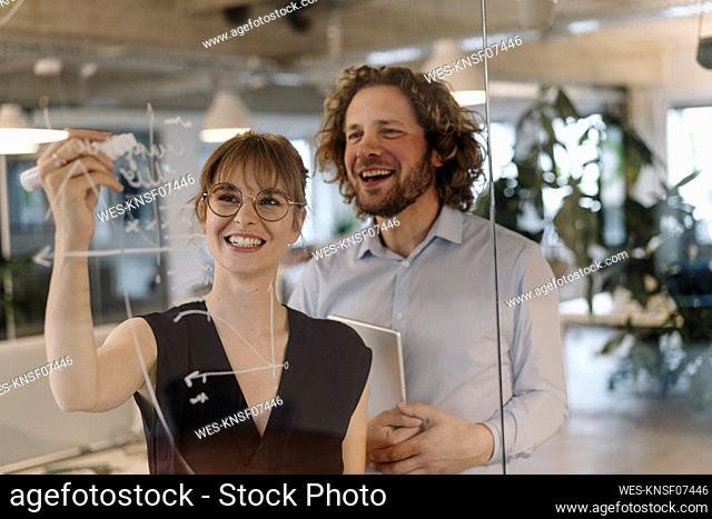 Happy businessman and businesswoman working on a project in office