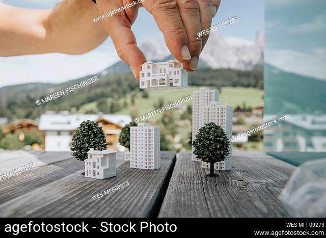 Hand of engineer positioning model home on table