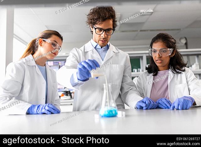 scientists with chemicals working in laboratory