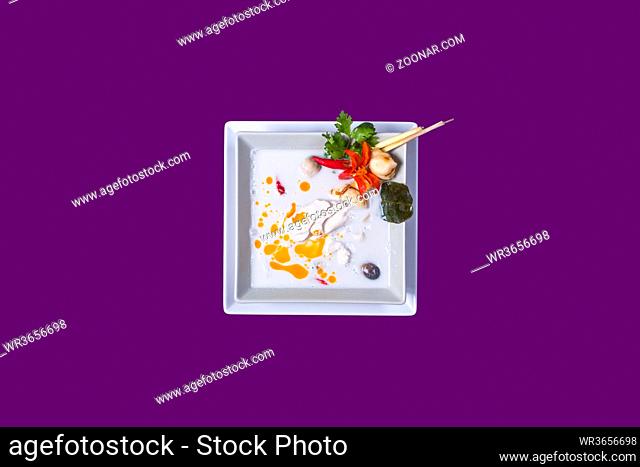 Tom kha gai. Asian Thai food on white plates with purple background with copy space
